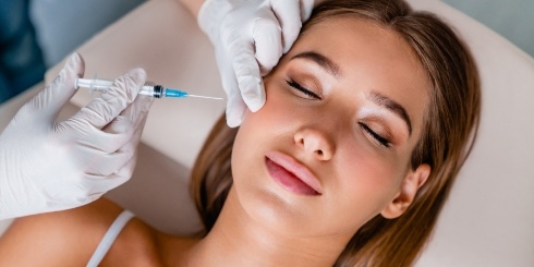 Woman receiving Botox injection in cheek