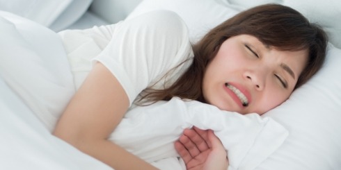 Woman grinding her teeth during sleep