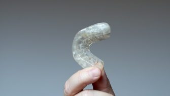 Hand holding a mouthguard