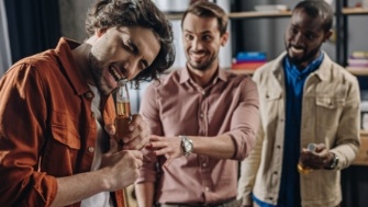 Man using teeth to open a bottle