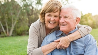 Man and woman enjoying the long term benefits of dental implants