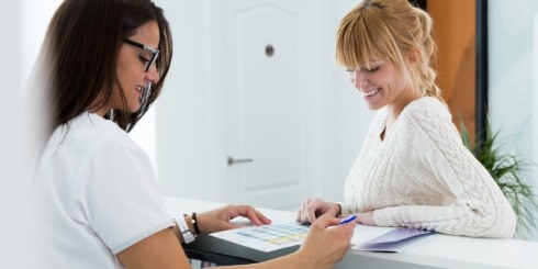 Dental team member and patient discussing the cost of dental implants