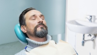Man relaxing during preliminary treatment and dental implant surgery