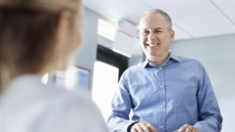 Smiling man in dental office reception area