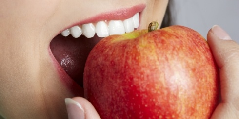 Closeup of person biting into an apple