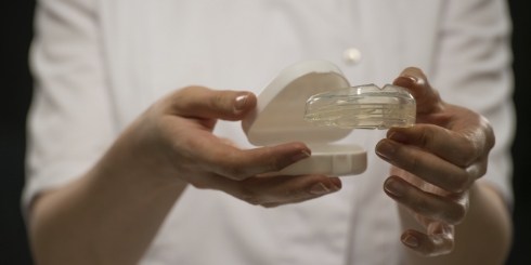 Dentist holding custom nightguard for bruxism