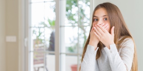 Woman with bad breath covering her mouth