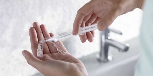 Person using at home teeth whitening kit