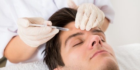 Man receiving Botox injection in forehead