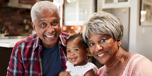 grandparents smiling with their grandchild