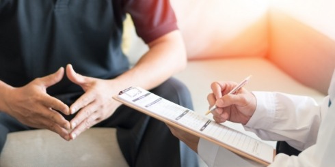 Dentist talking to dental patient during oral cancer screening