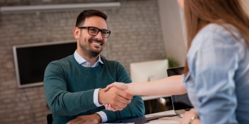 Man talking to dental team member about the cost of veneers