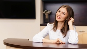 Woman at dental office reception desk