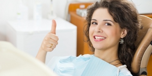 Woman giving thumbs up after gum disease treatment